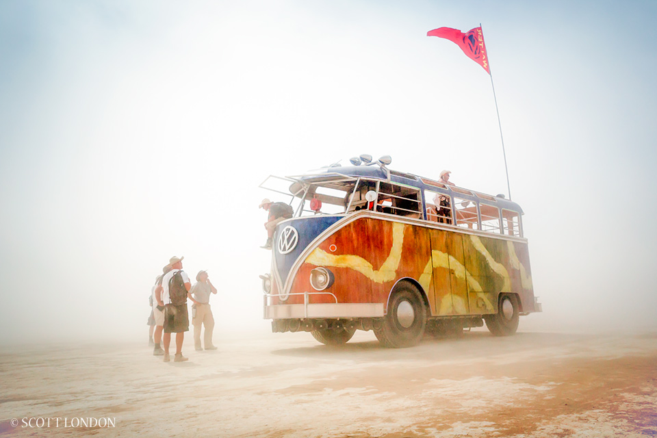 Walter, an art car built around the chassis of an old firetruck, is billed as the world's largest VW bus. Here the driver and a few curious passersby wait out a duststorm. (Photo by Scott London)