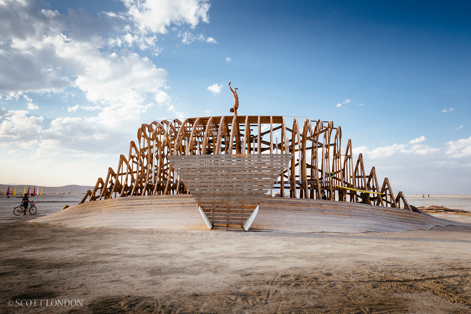 Moment does a handstand on top of 'Cruz the Wave,' an art installation at Burning Man 2014 (Photo by Scott London)