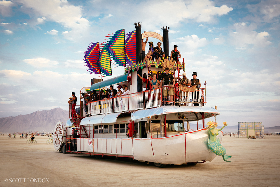 Lady Sassafras, an art car built atop an old school bus, carries a boatload of people across the playa at Burning Man 2014. (Photo by Scott London)