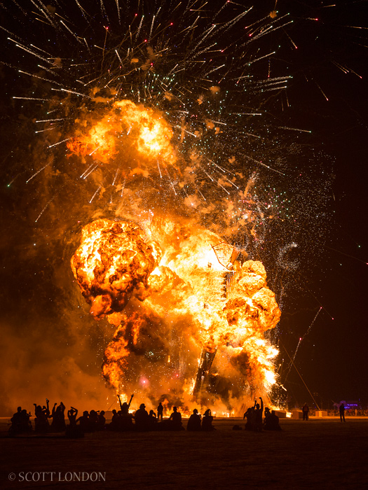 The man explodes in a ball of flames and fireworks at Burning Man 2014 (Photo by Scott London)