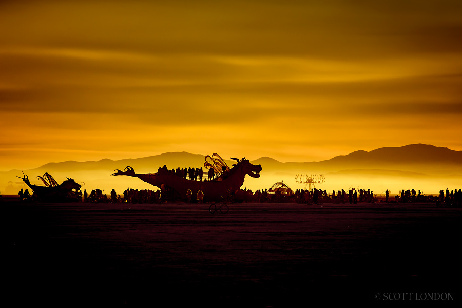 Crowds gather at the Abraxas art car for a golden sunrise on the final day of Burning Man 2015. (Photo by Scott London)