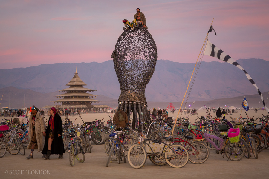 Two Burners take in the sunrise from a perch on top of 'Oid,' an installation by Michael Christian at Burning Man 2016. (Photo by Scott London)