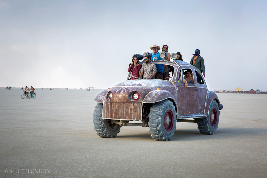 People crowd into Big Red, an oversize VW beetle at Burning Man 2016. (Photo by Scott London)