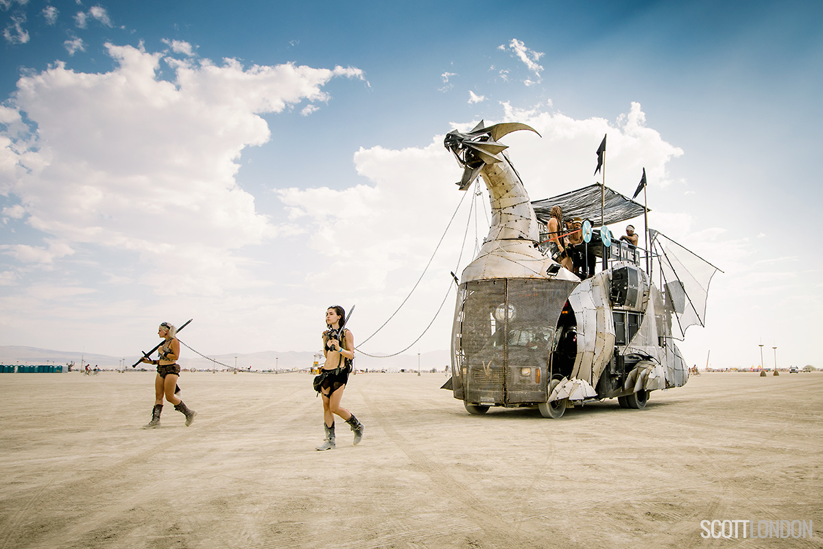 Two women guide Heavy Meta, an art car in the shape of a metal dragon, at Burning Man 2017. (Photo by Scott London)