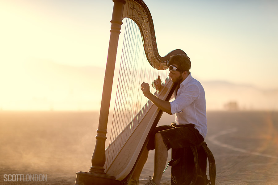 A harpist performs out on the open playa at Burning Man 2017. (Photo by Scott London)