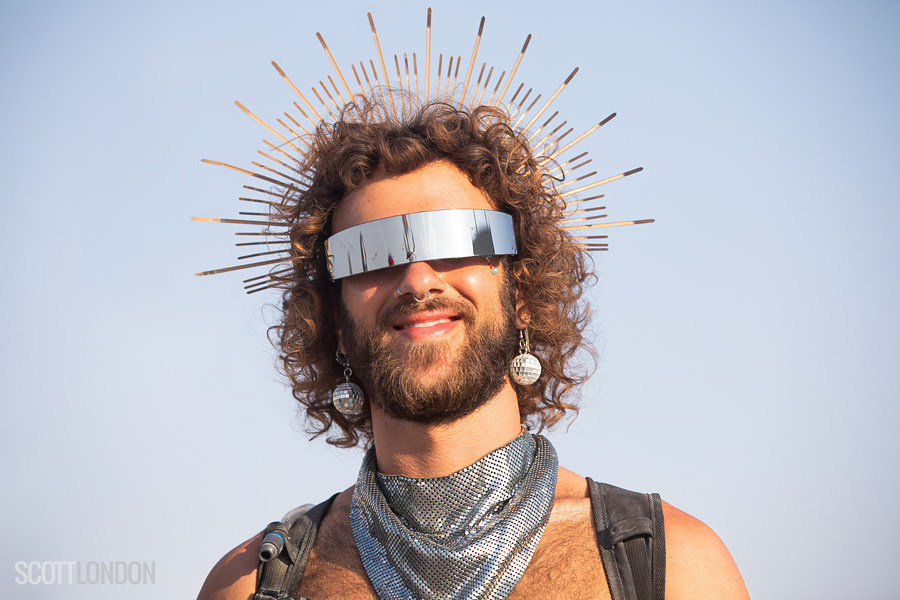 A Burner wearing a visor and disco-ball earrings at Burning Man 2018. (Photo by Scott London)